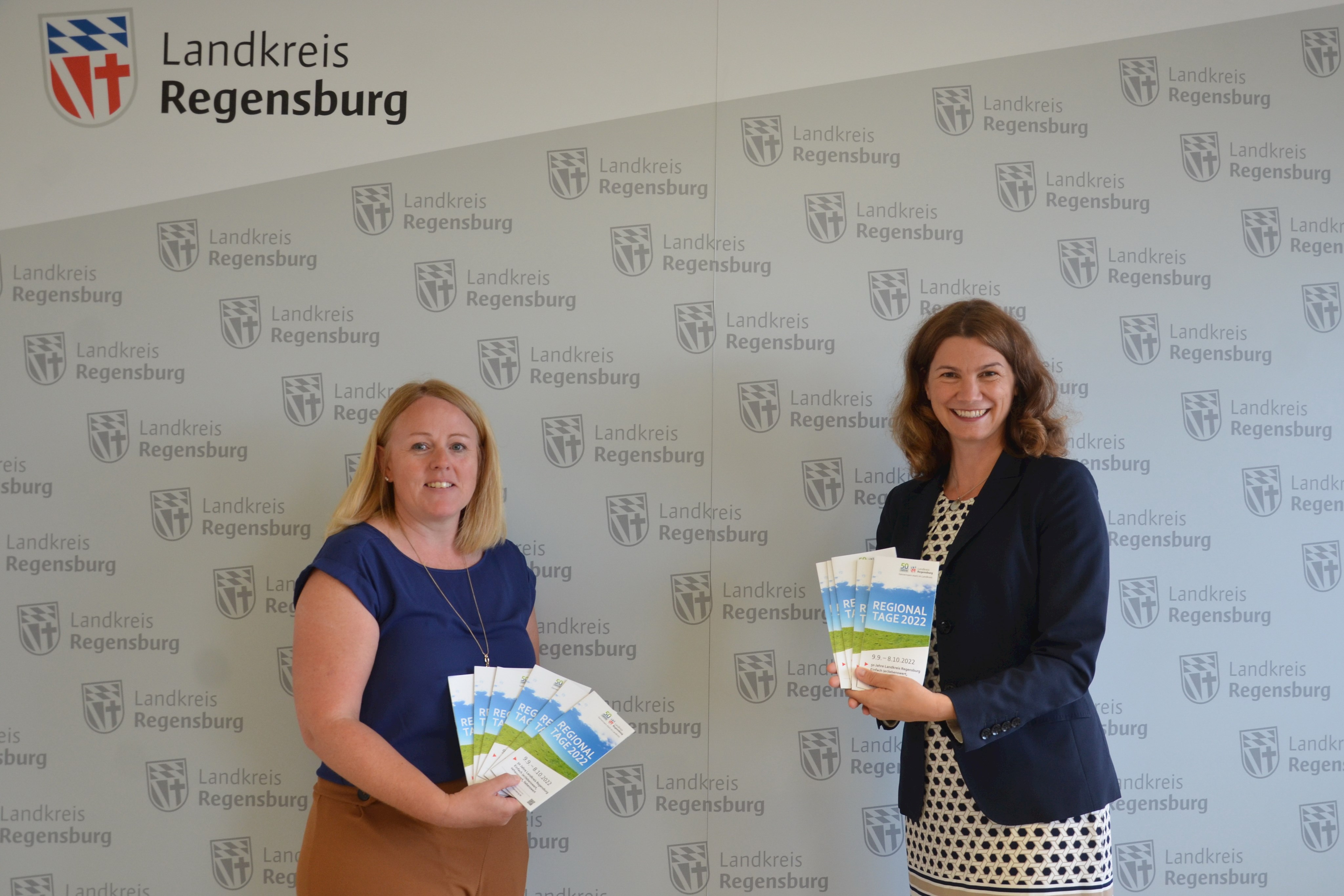 Landrätin Tanja Schweiger (rechts) und Christine Lang vom Sachgebiet Wirtschaft, Regionalentwicklung und Tourismus präsentieren den neuen Flyer zu den Regionaltagen 2022. (Foto: Birgitt Retzer)